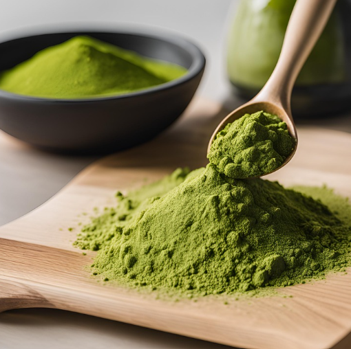 Green tea powder piled on a wooden board with a wooden spoon and a black bowl of powder behind it