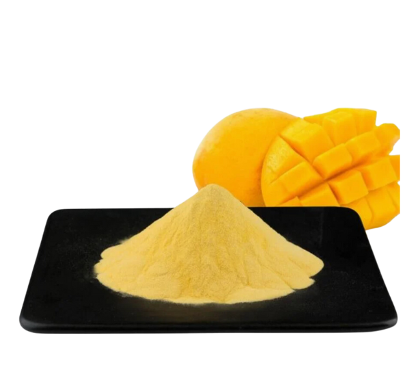 Yellow mango powder piled on a black plate with whole and diced mango behind it